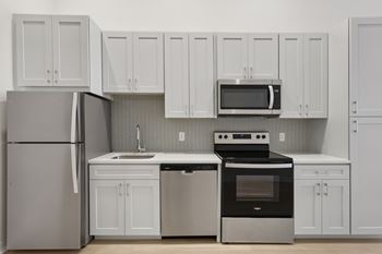 A kitchen with white cabinets and appliances. at LiveWell Apartments, Pennsylvania